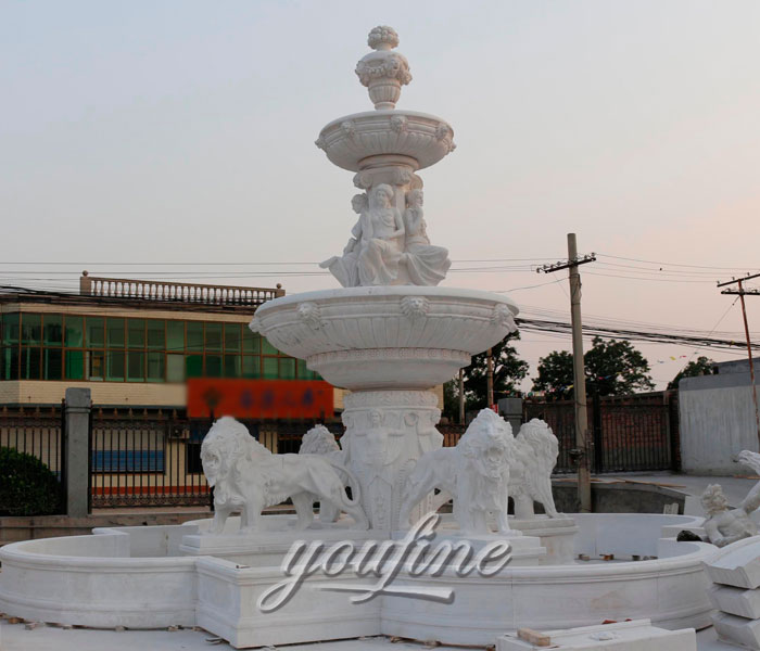 Large pure white tiered lion water fountains with woman statues outdoor
